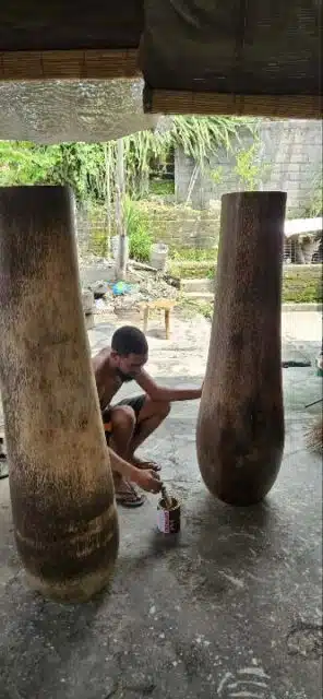 Balinesische Handarbeit – Kunsthandwerker auf Bali bei der traditionellen Fertigung: Lackieren einer 2m hohen Vase