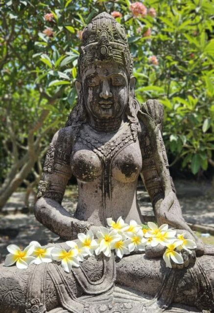 Bali Statue mit Blütenschmuck