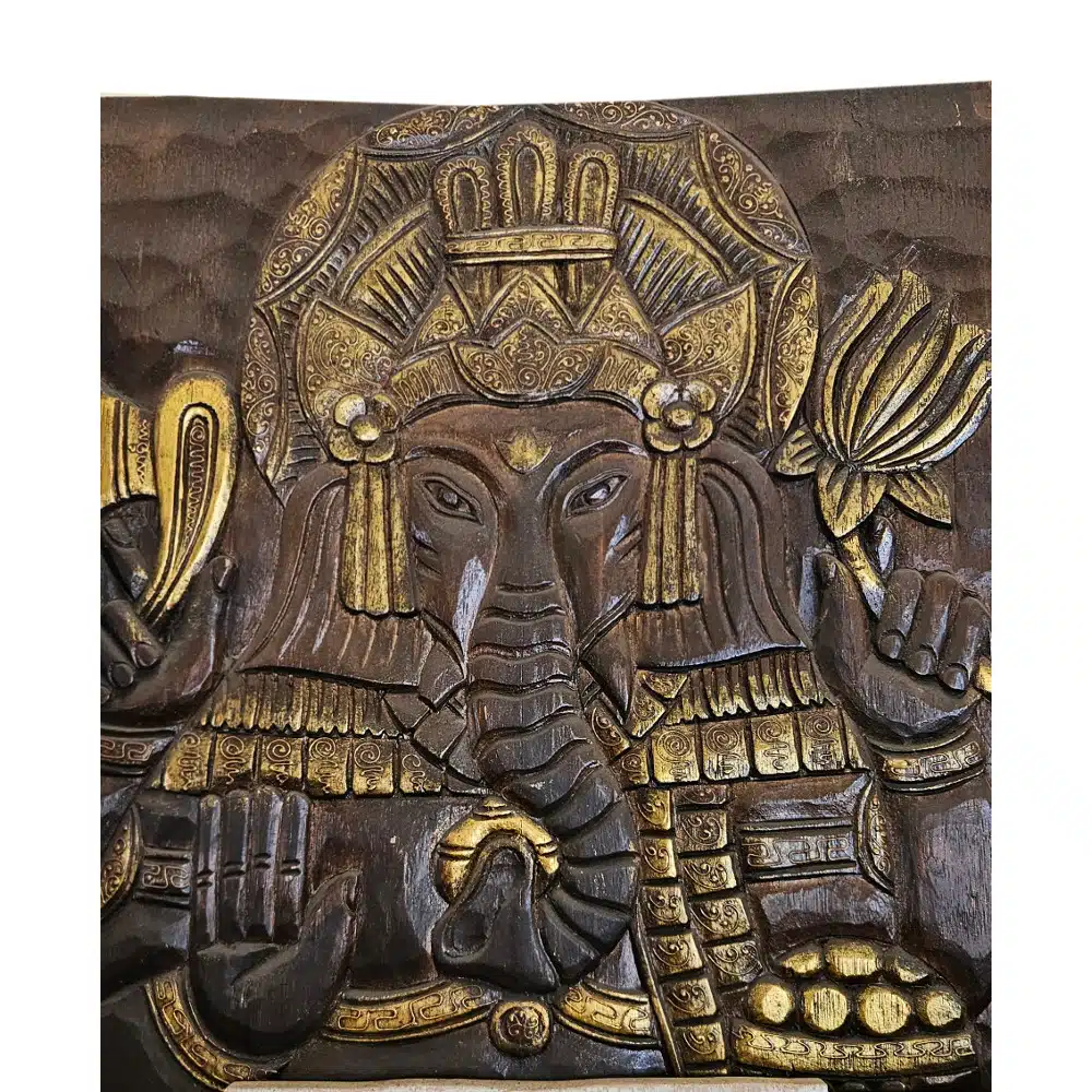 Ganesha Wandbild Gold auf Dunkelbraun aus Albesia, einteilig, 100 x 60 cm 1 Ein kunstvoll geschnitztes Holzrelief des Hindu-Gottes Ganesha, der einen Elefantenkopf besitzt. Das Relief ist in dunklem Holz gehalten und mit goldenen Akzenten verziert, die Details wie den Kopfschmuck, Schmuck und die Gegenstände, die er in seinen Händen hält, hervorheben. Ganesha ist frontal abgebildet, mit seinen charakteristischen Merkmalen wie dem Rüssel und den großen Ohren.